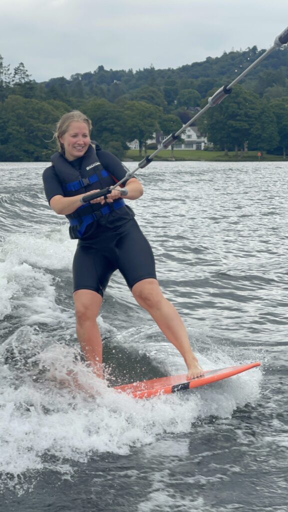 Claire wakesurfing on lake windermere and holding on to the rope
